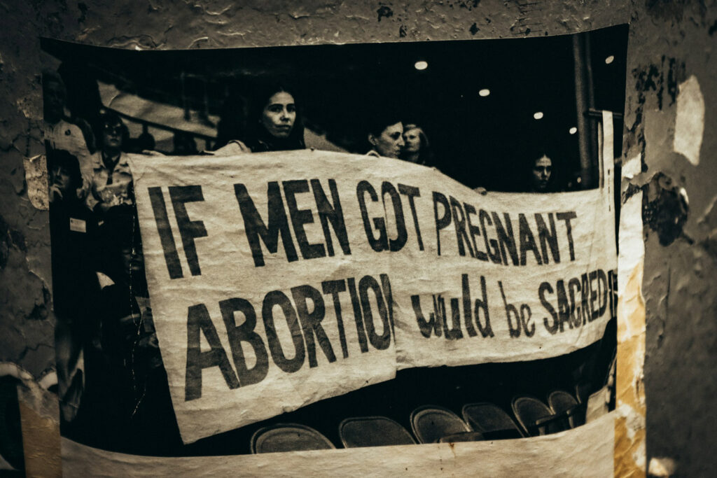 Sticker von Protestbanner für das Recht auf Schwangerschaftsabbruch mit Aufschrift "If men got pregnant, abortion would be sacred"