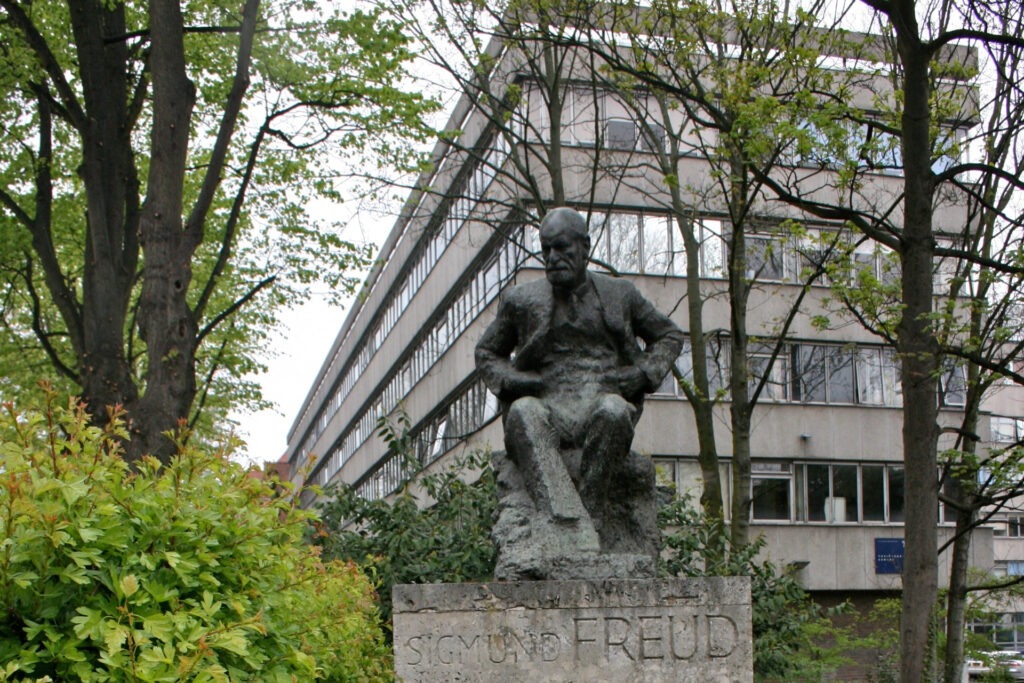Die Statue von Sigmund Freud, im Hintergrund das Gebäude der Londoner Tavistock-Klinik. Symbolbild für Artikel "Jenseits der Bestätigung: Lehren aus Tavistock"