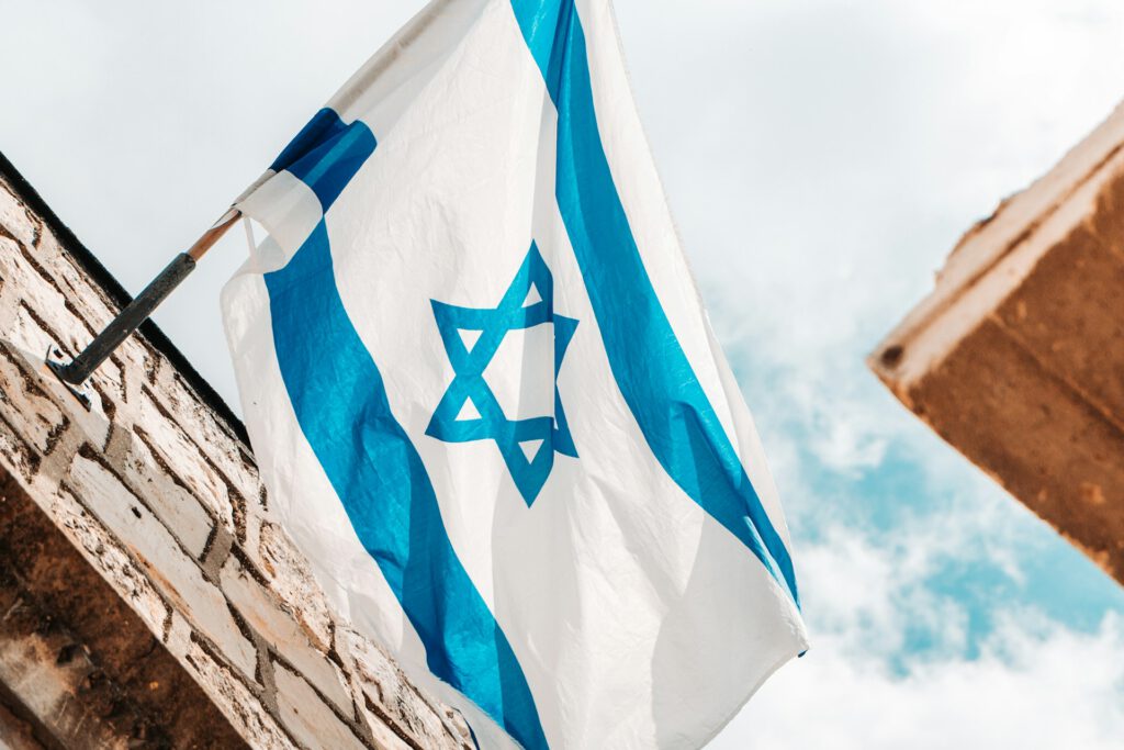 Eine Israelflagge hängt von einer Hauswand herunter. Symbolbild für Artikel "CSD-Saison: Pride in Tel Aviv, Ausgrenzung in Rom"